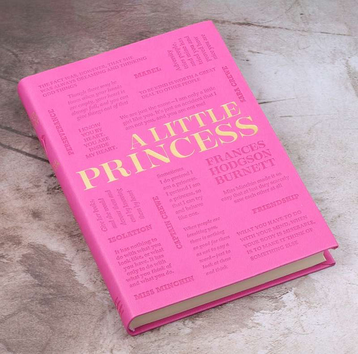 Pink book titled 'A Little Princess' by Frances Hodgson Burnett on a wooden surface