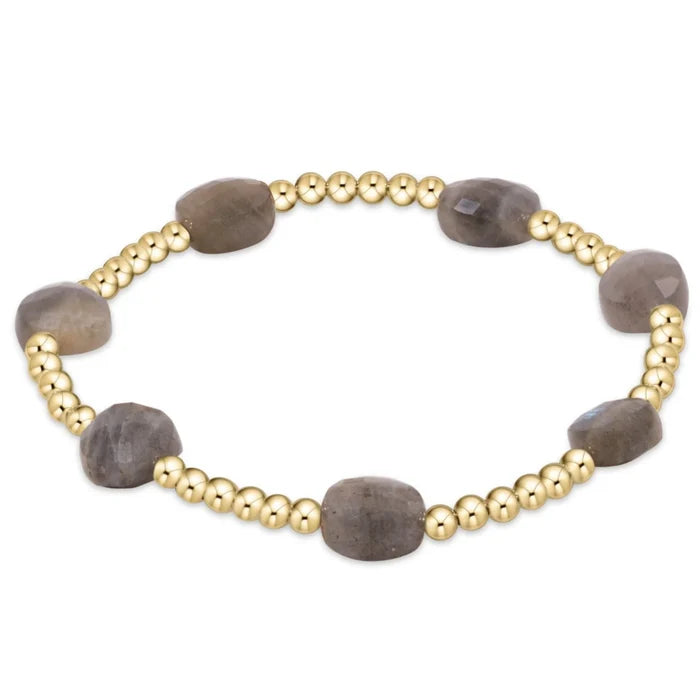 Gold bead stackable bracelet with 8 millimeter labradorite faceted gemstones between every six 3 millimeter beads.