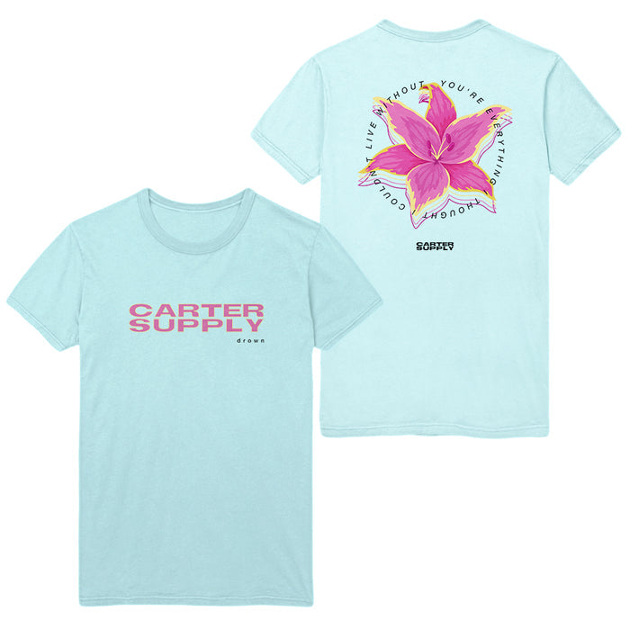 Light blue t-shirt by Tyler Carter with pink “CARTER SUPPLY CO.” on the front. Back shows a large pink flower, green leaves, and “LIVE WITHOUT YOU’RE DOING NOTHING” in a circular design.
