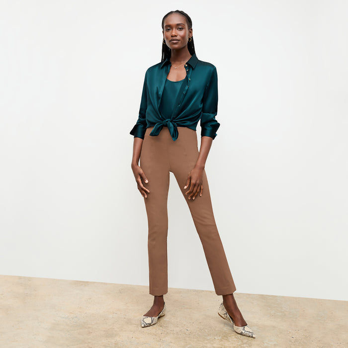 Front image of a woman sitting wearing the Foster Pant—Everstretch in Saddle