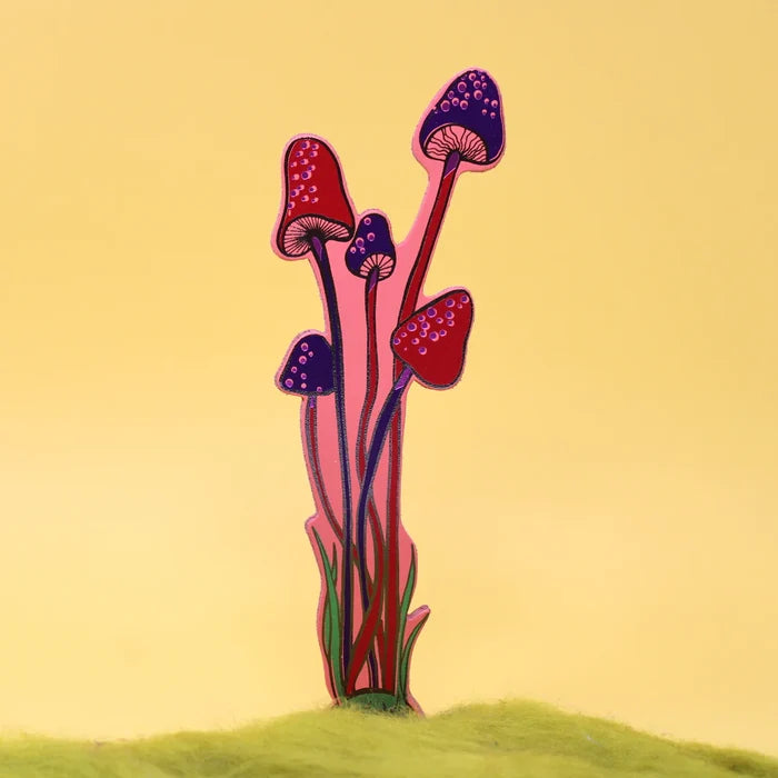 A pink with purple and red details bookmark shaped as a mushrooms against a solid light yellow background.
