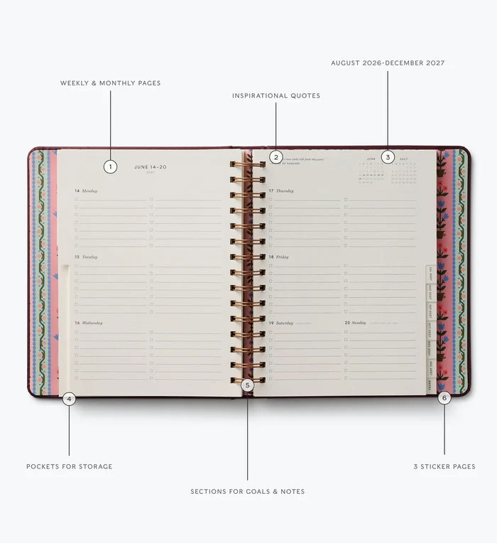 An open spiral-bound planner or agenda shown on a light gray background with callout labels pointing to features such as weekly and monthly pages, inspirational quotes, sticker pages, pockets for storage, and sections for goals and notes.