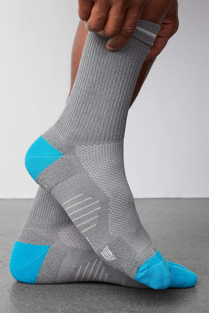 Side view of a man wearing AIRKNITx Crew Sock in Grey Heather