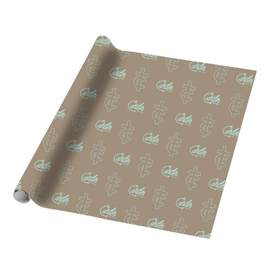 An 18 x 18 brown wrapping paper from Tyler Carter features a repeating pattern of light blue stylized letters and the word Cater in cursive. The partially unrolled sheet is shown on a white background.