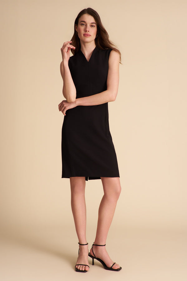 Woman wearing a black sleeveless dress on a beige background | Exclude