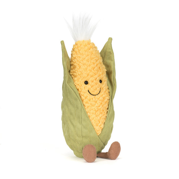 Plush toy resembling a corn on the cob with a smiling face and small legs on a white background