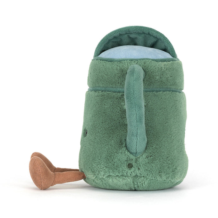 Plush toy watering can with a smiling face and small legs on a white background from a side angle.
