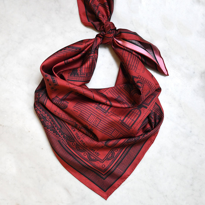 Red and pink double-sided scarf featuring architectural drawings of NYPL's flagship building in black.