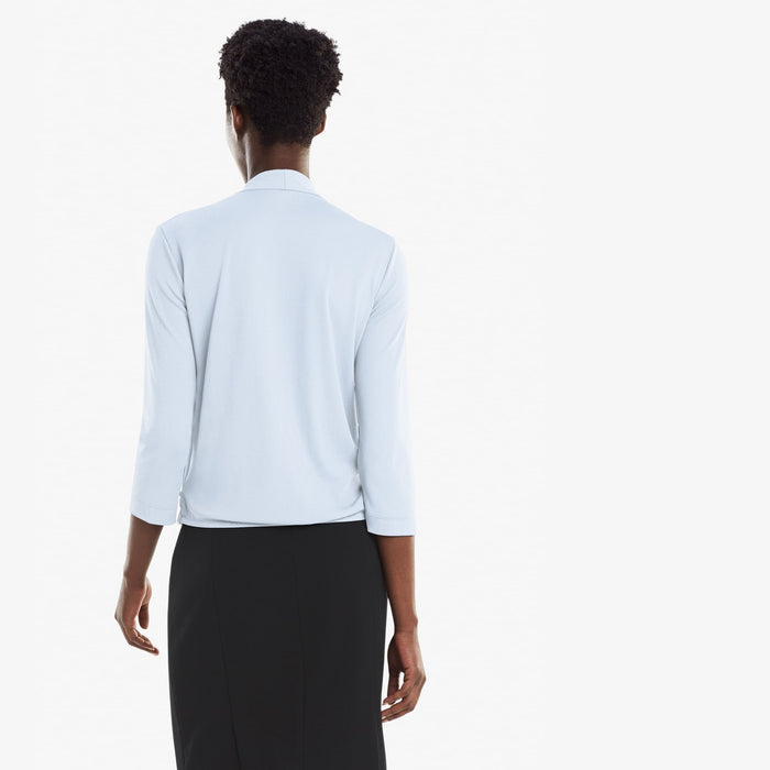 Back image of a woman standing wearing the Deneuve top in Oxford Blue