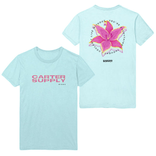 Light blue t-shirt by Tyler Carter with pink “CARTER SUPPLY CO.” on the front. Back shows a large pink flower, green leaves, and “LIVE WITHOUT YOU’RE DOING NOTHING” in a circular design.