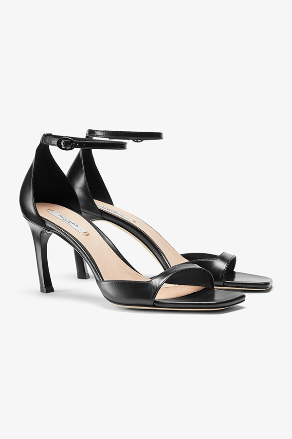 Packshot image of a woman standing wearing the Ella sandal in black | Grid | Still | Exclude