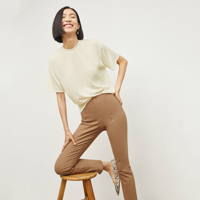 Front image of a woman sitting wearing the Foster Pant—Everstretch in Saddle | Lead