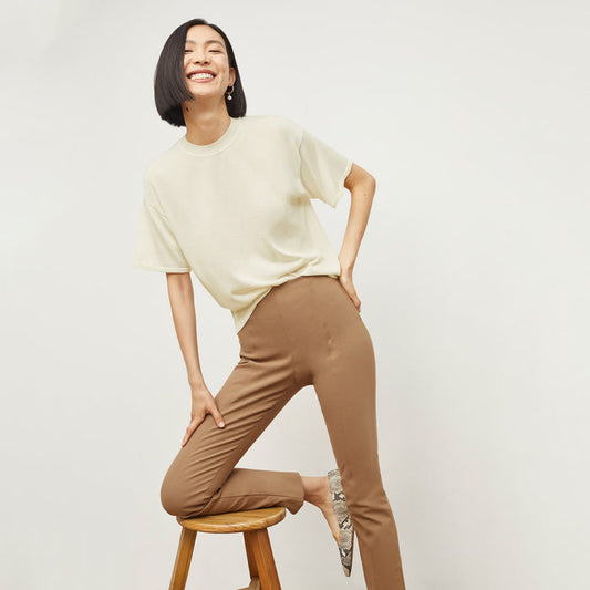 Front image of a woman sitting wearing the Foster Pant—Everstretch in Saddle | Lead