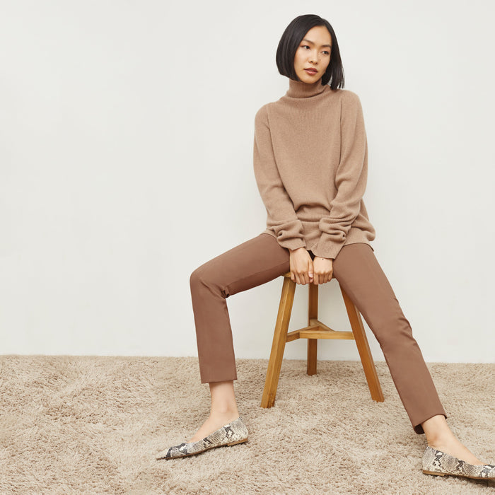 Front image of a woman sitting wearing the Foster Pant—Everstretch in Saddle