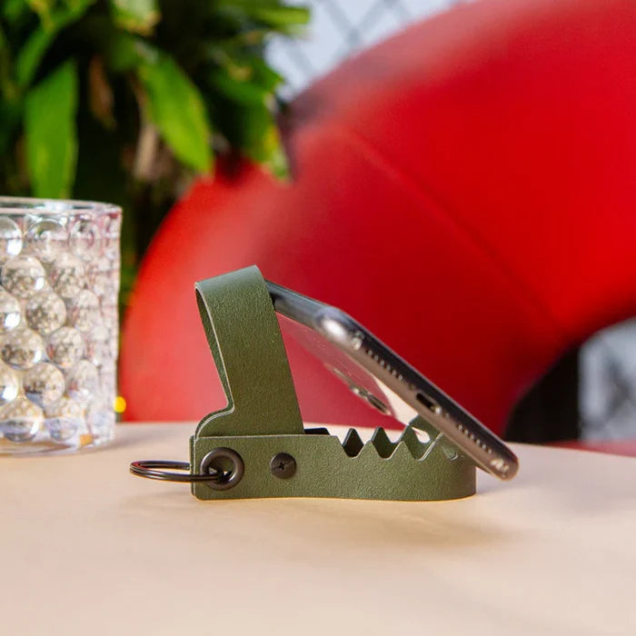 Phone stand simulating a green gator with an open mouth.