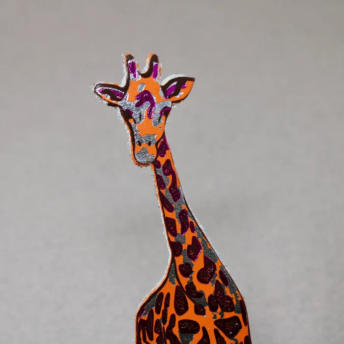 Colorful giraffe bookmark in orange and silver, and pink on a gray background