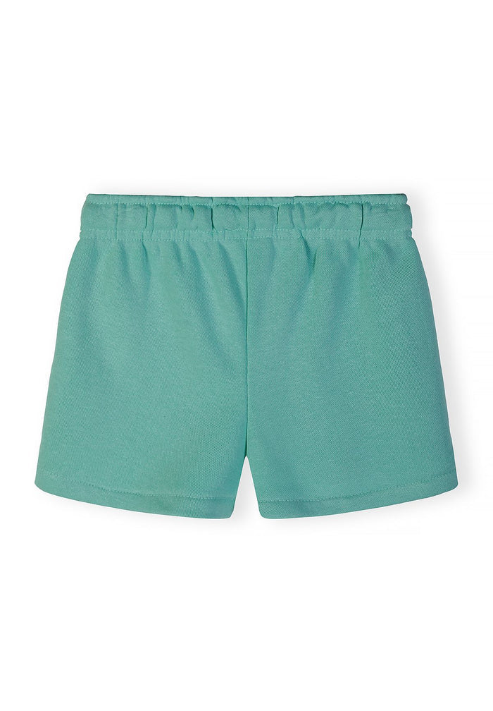 Girls' shorts in light green, back view, featuring an elasticated waistband.
