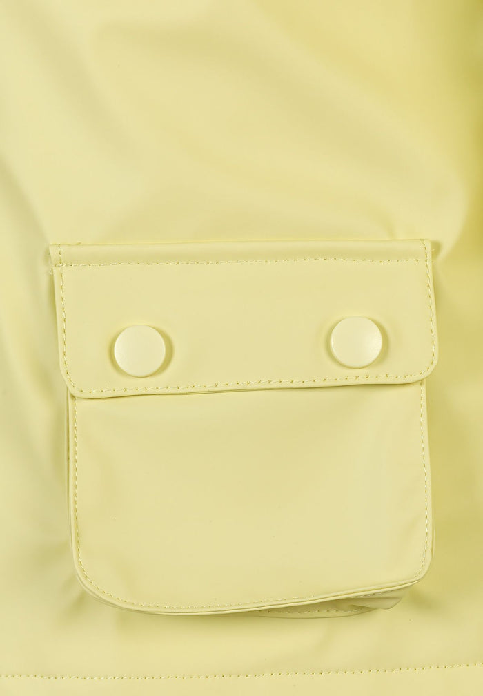 Detail of a bright yellow waterproof jacket with a snap-button pocket.