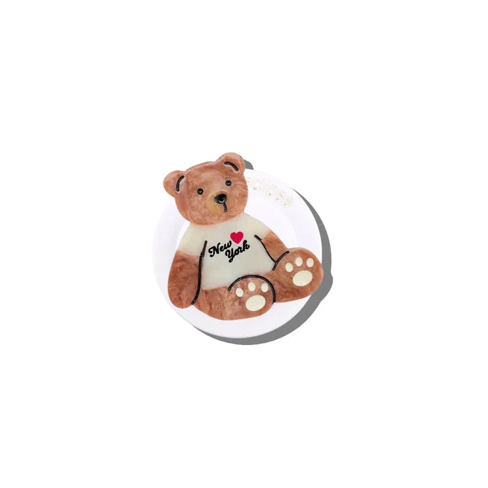 Small teddy bear phone holder with a white shirt on a white background