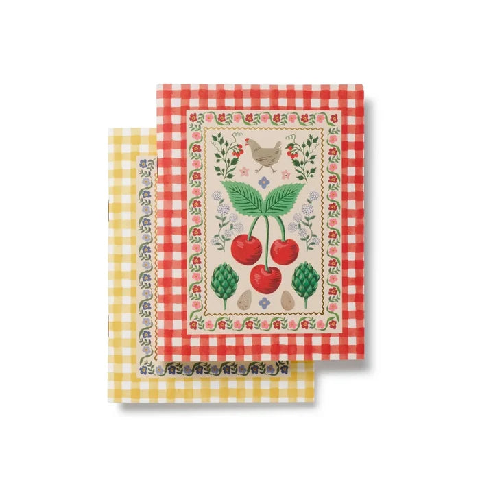 Two notebooks with a red & yellow checkered border and cherry design on a white background.