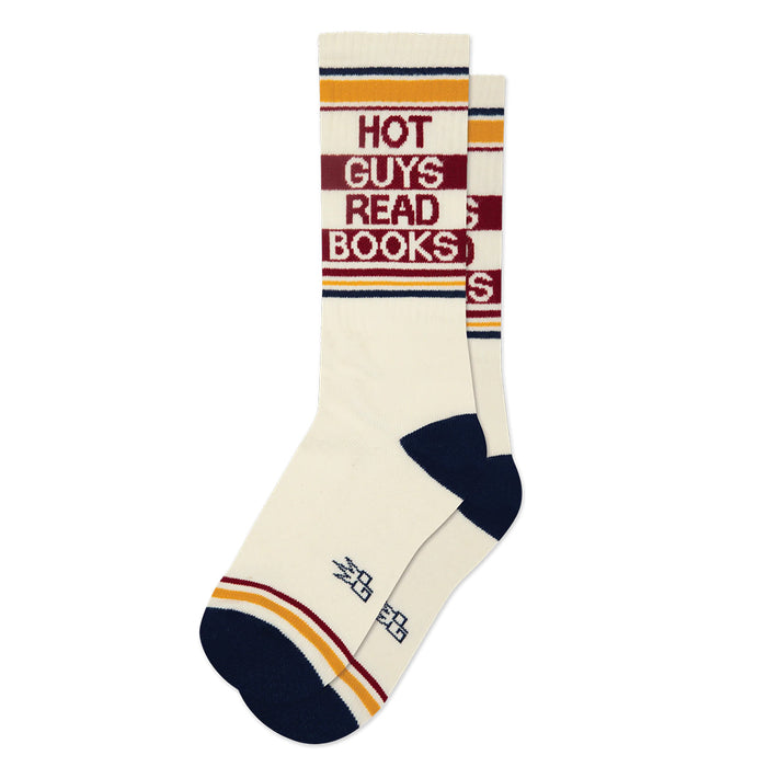 A pair of crew socks with a cream base, navy blue heels and toes, and orange and maroon stripes. The front sock features the text 'HOT GUYS READ BOOKS' in maroon and cream lettering.