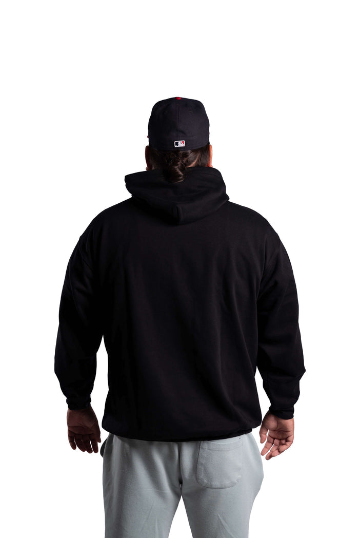 Person wearing a black INAC Distressed Feather hoodie back view with cap