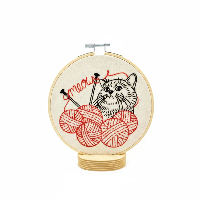 Embroidery hoop with a cat and yarn design on a white background