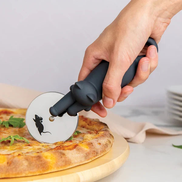 Person using a pizza cutter with a cat design on a pizza