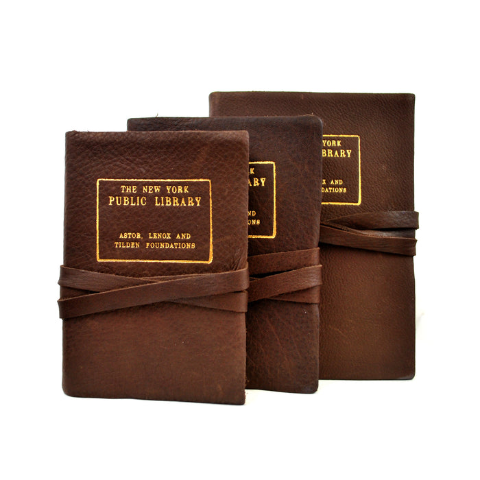 Three Italian leather journals with The New York Public Library gold stamp, tied with string.