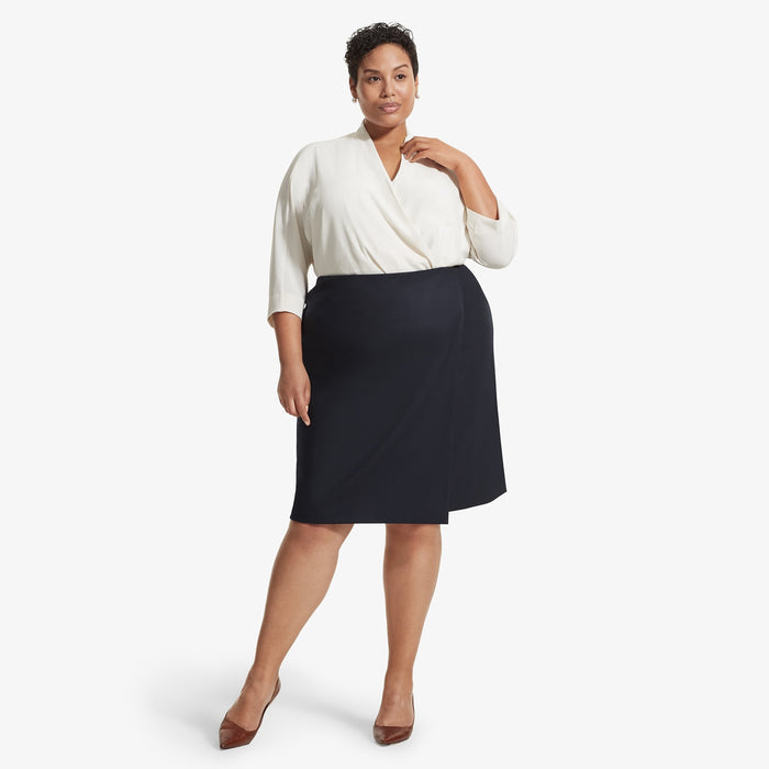 Front image of a woman standing wearing the Logan skirt sharkskin in Ink