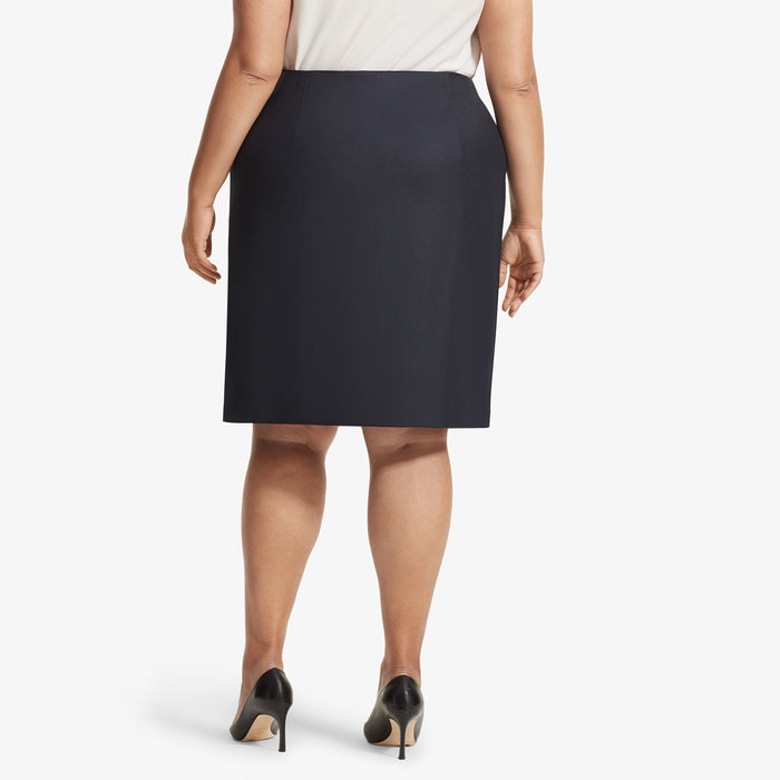 Back image of a woman standing wearing the Logan skirt sharkskin in Ink