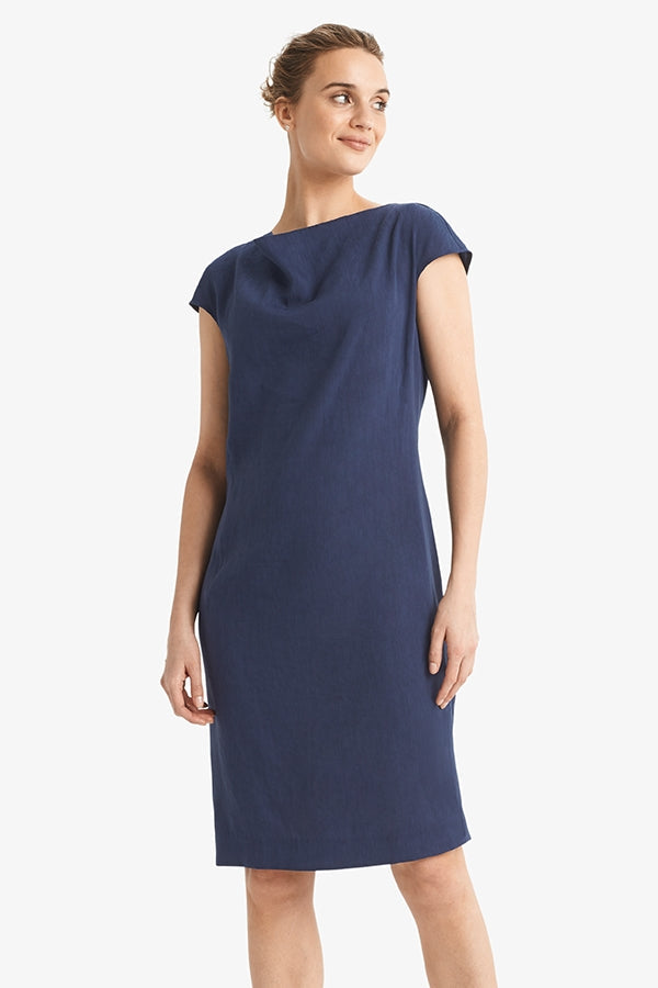 Front image of a woman standing wearing the Marilyn dress stretch linen in blueberry | Grid | Exclude