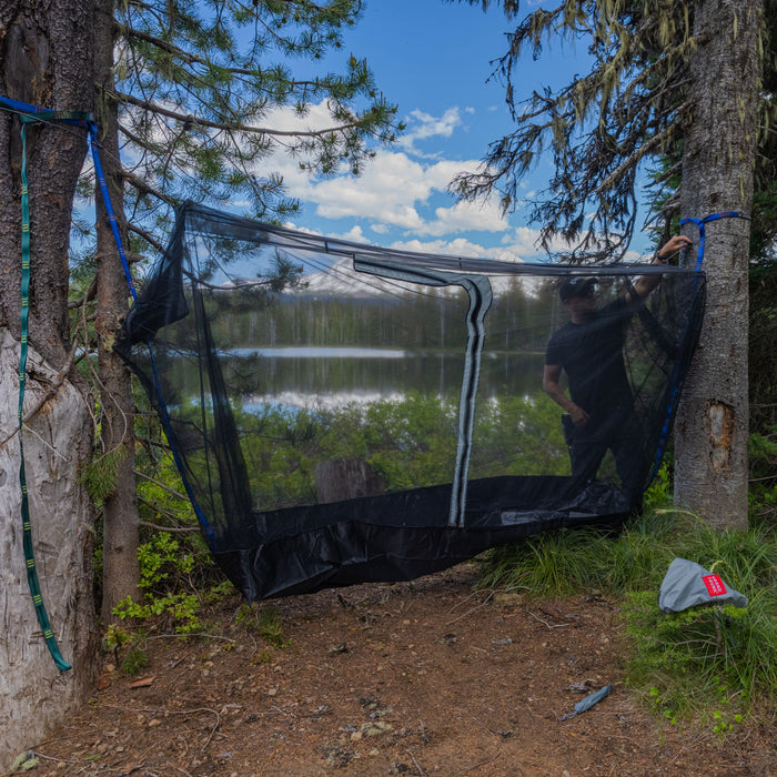 setting up the mozzy 360 between trees for a perfect bug-free shelter