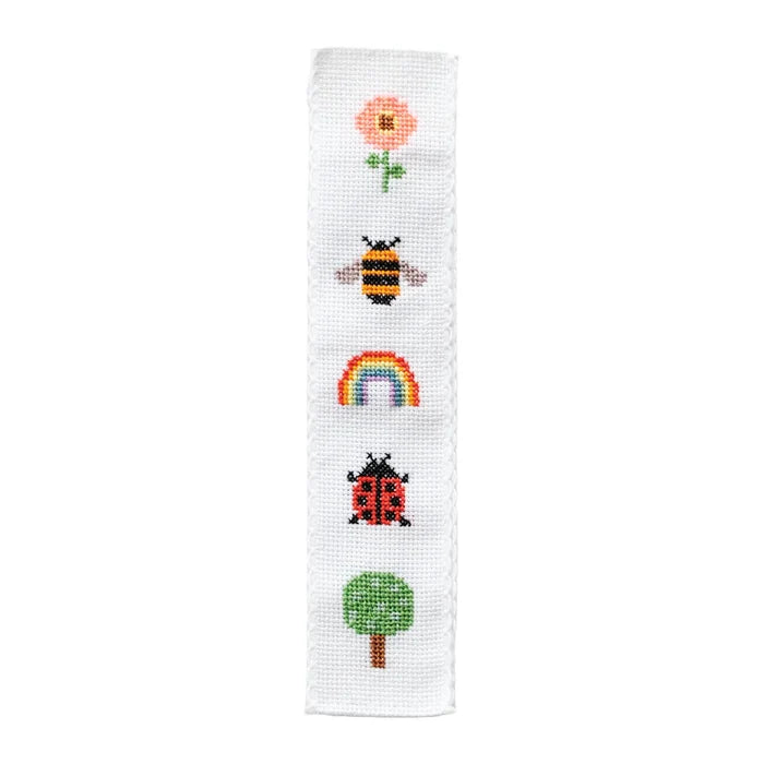 Cross-stitched bookmark design with a tree, rainbow, bee, and flower on a white background