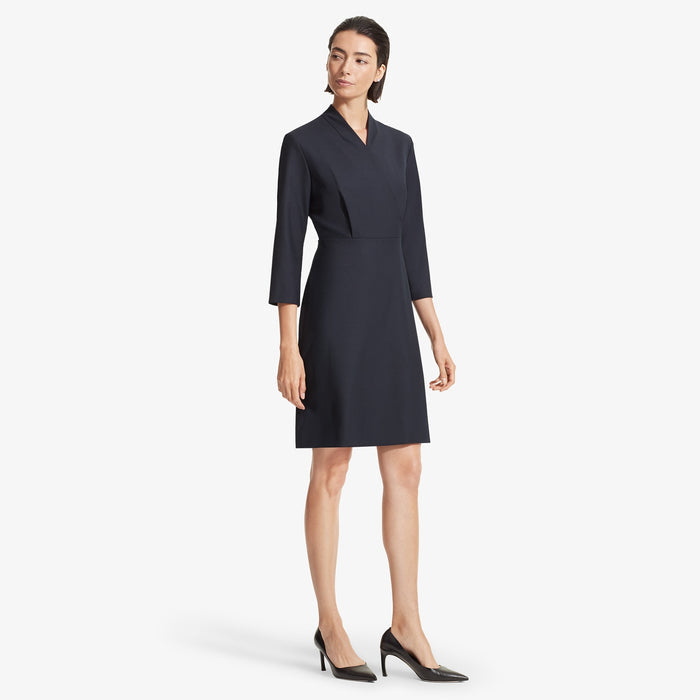 Side image of a woman standing wearing the Niko dress sharkskin in Ink