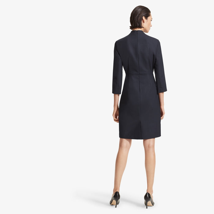 Back image of a woman standing wearing the Niko dress sharkskin in Ink