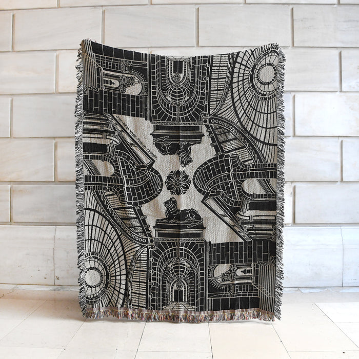 Decorative throw blanket with architectural design of NYPL's flagship building in black and beige.