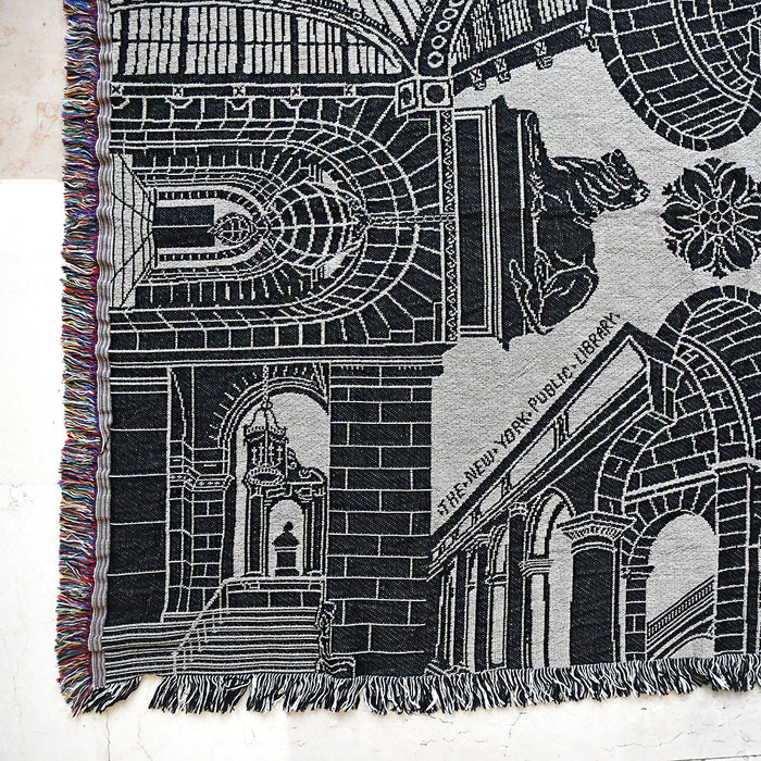 Woven blanket with architectural design of NYPL's flagship email and 'The New York Public Library' text.