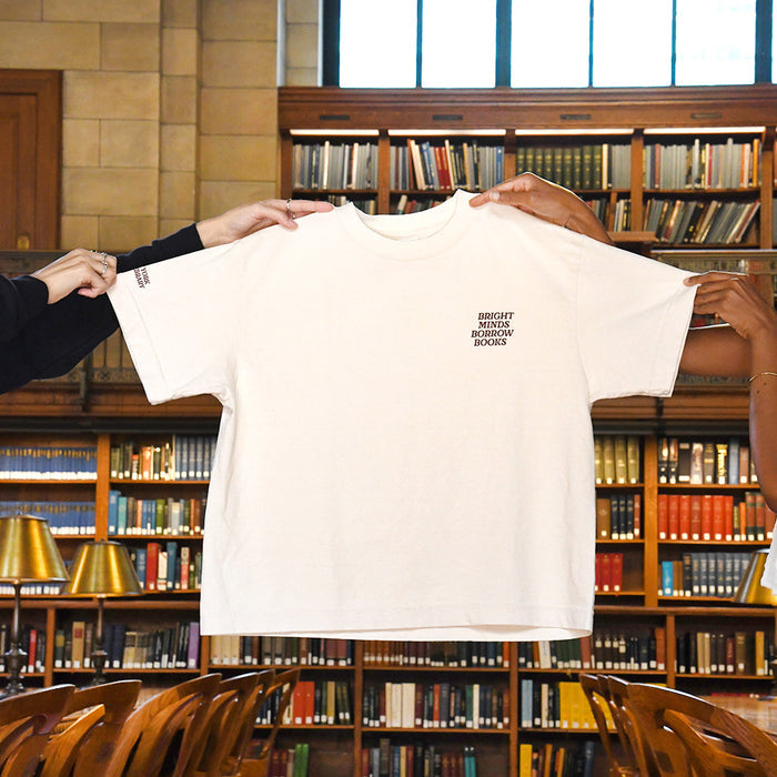 Cream-colored t-shirt with dark red text on the left chest that reads 'BRIGHT MINDS BORROW BOOKS'.