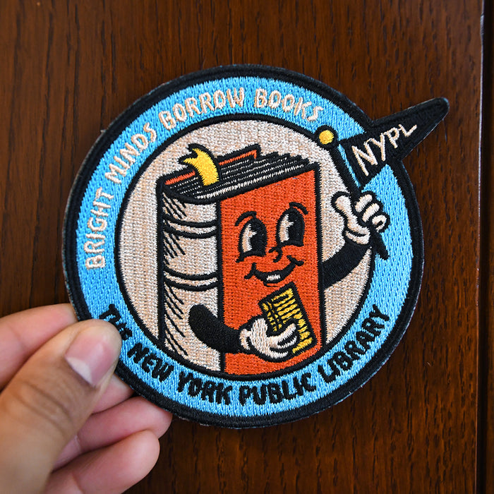 Patch being hold by a person on a wooden background.