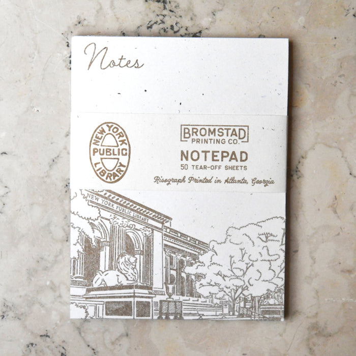 A direct top-down shot of the notepad with its branded belly band. The word "Notes" is at the top, and a detailed architectural sketch of the library is at the bottom.