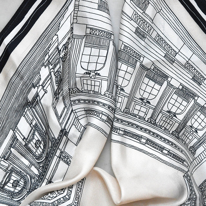 Close-up of the off-white silk scarf featuring a detailed black line-art illustration of NYPL's flagship building.
