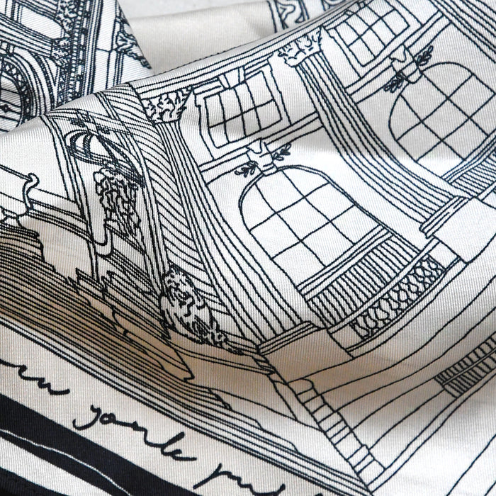 Close-up of the off-white silk scarf featuring a detailed black line-art illustration of NYPL's flagship building.
