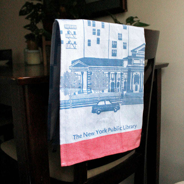 Towel with New York Public Library design hanging on a chair