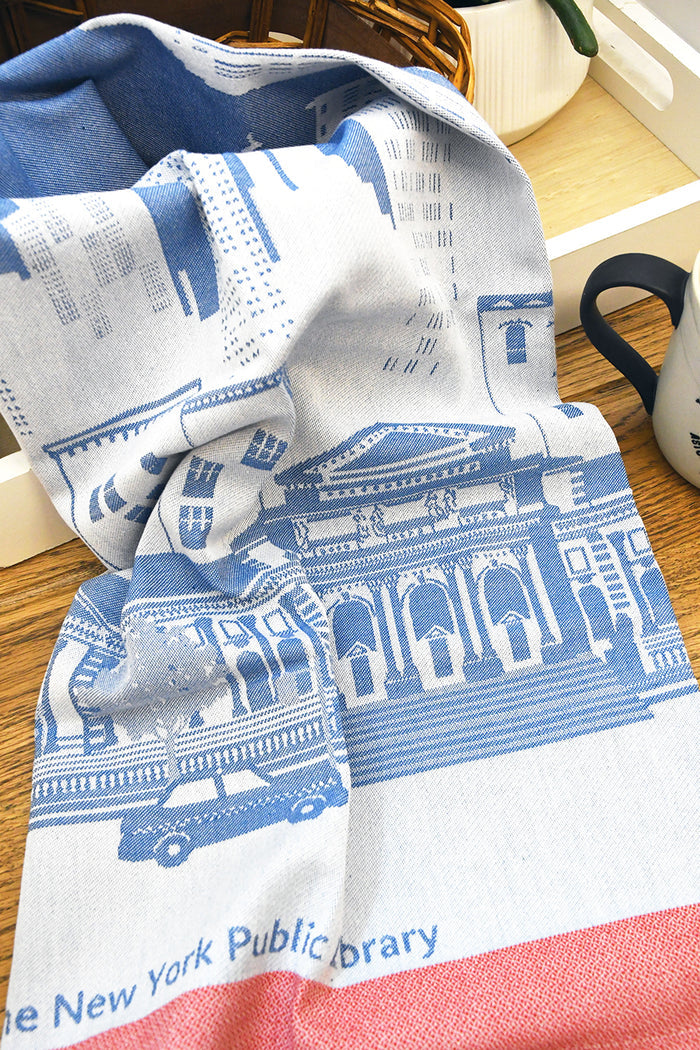 Tea towel with blue and red design on a wooden surface