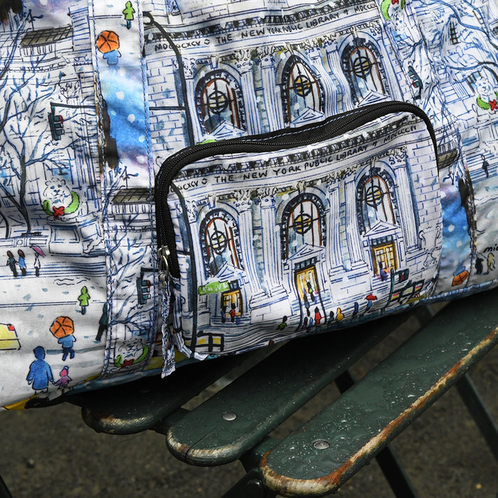 Close-up of the foldable duffle bag featuring an illustration of the NYPL's flagship building during the winter season.