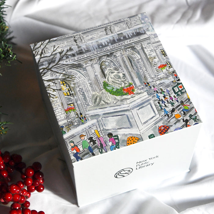 Illustrated box with a design of the NYPL flagship building during the holidays on a white surface.