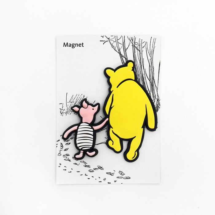 A rubber magnet shaped as Winnie-the-Pooh and Piglet with a backing card simulating the woods.