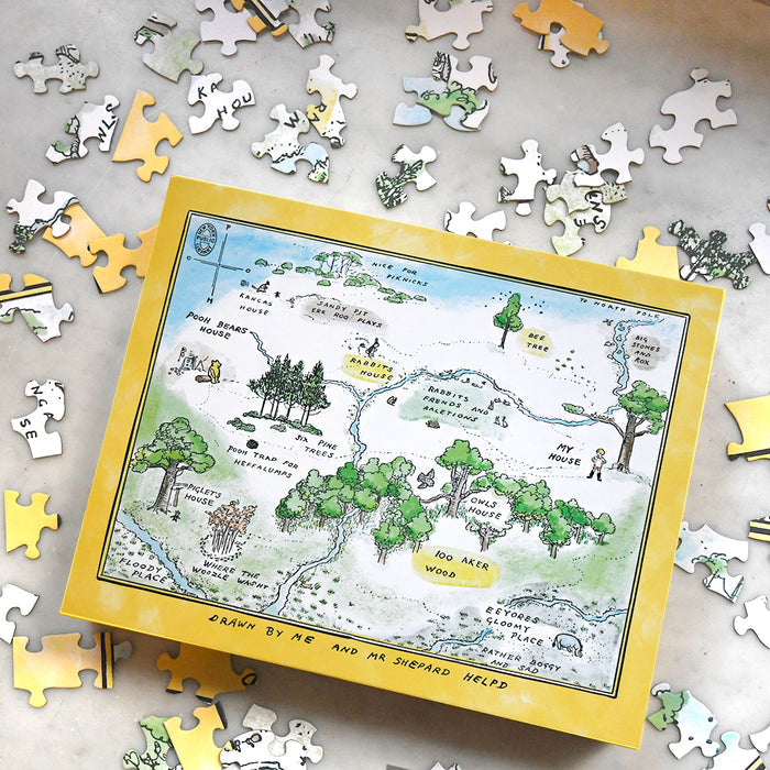 Jigsaw puzzle depicting the Hundred Acre Wood from the Winnie-the-Pooh series, with several puzzle pieces scattered around.