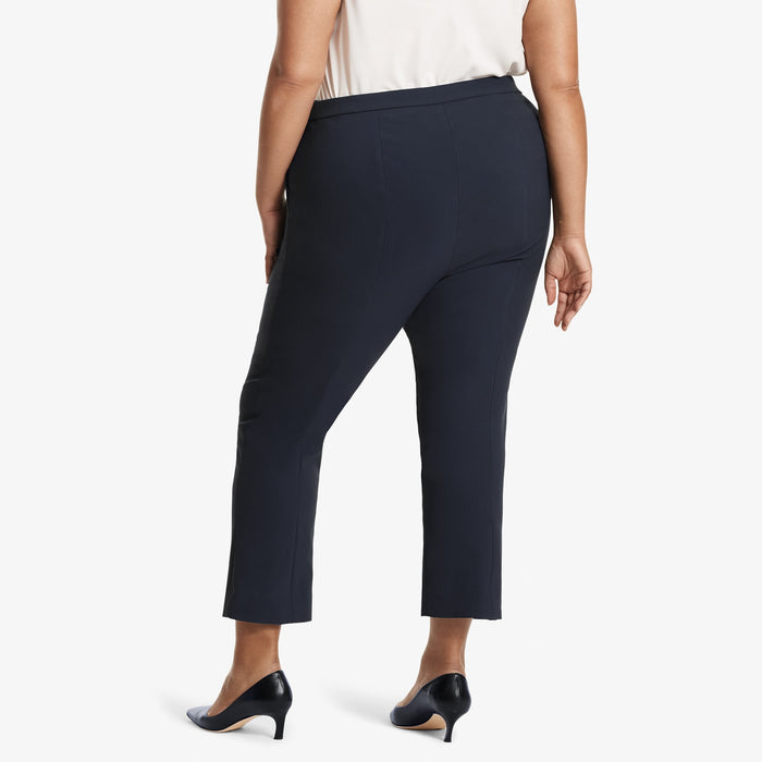 Back image of a woman standing wearing the Oshima pant in Dark navy